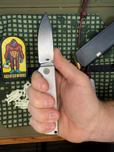 Folding knife with a cryo-treated 14C28N steel blade, featuring a durable Sasquatch-themed pocket clip and designed for everyday carry and outdoor performance.