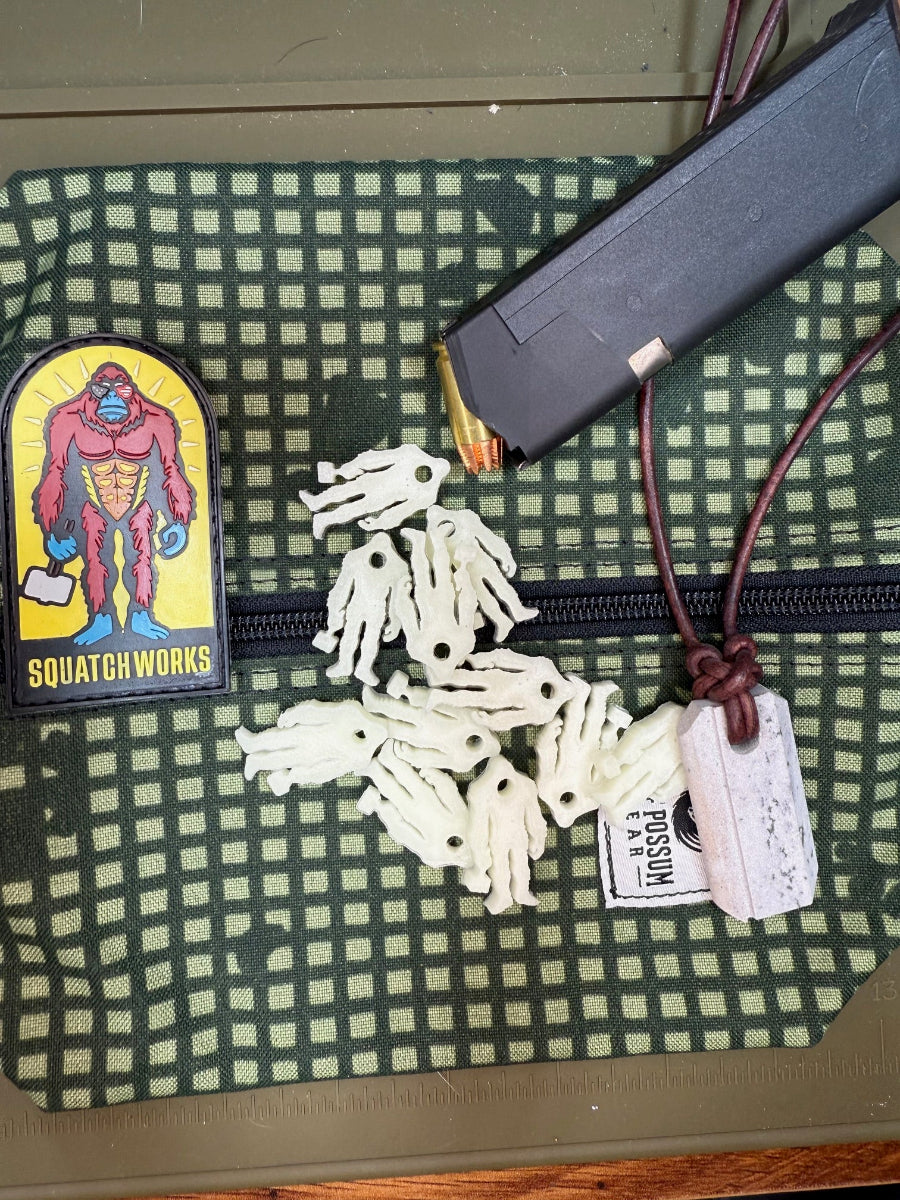 Squatch Works glow-in-the-dark lanyard bead featuring the signature Squatch Works logo, perfect for enhancing visibility and style on your gear.