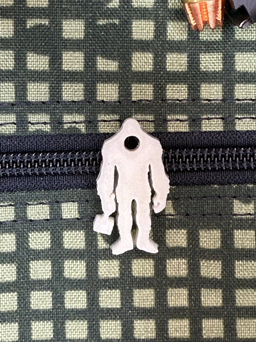 Squatch Works glow-in-the-dark lanyard bead featuring the signature Squatch Works logo, perfect for enhancing visibility and style on your gear.