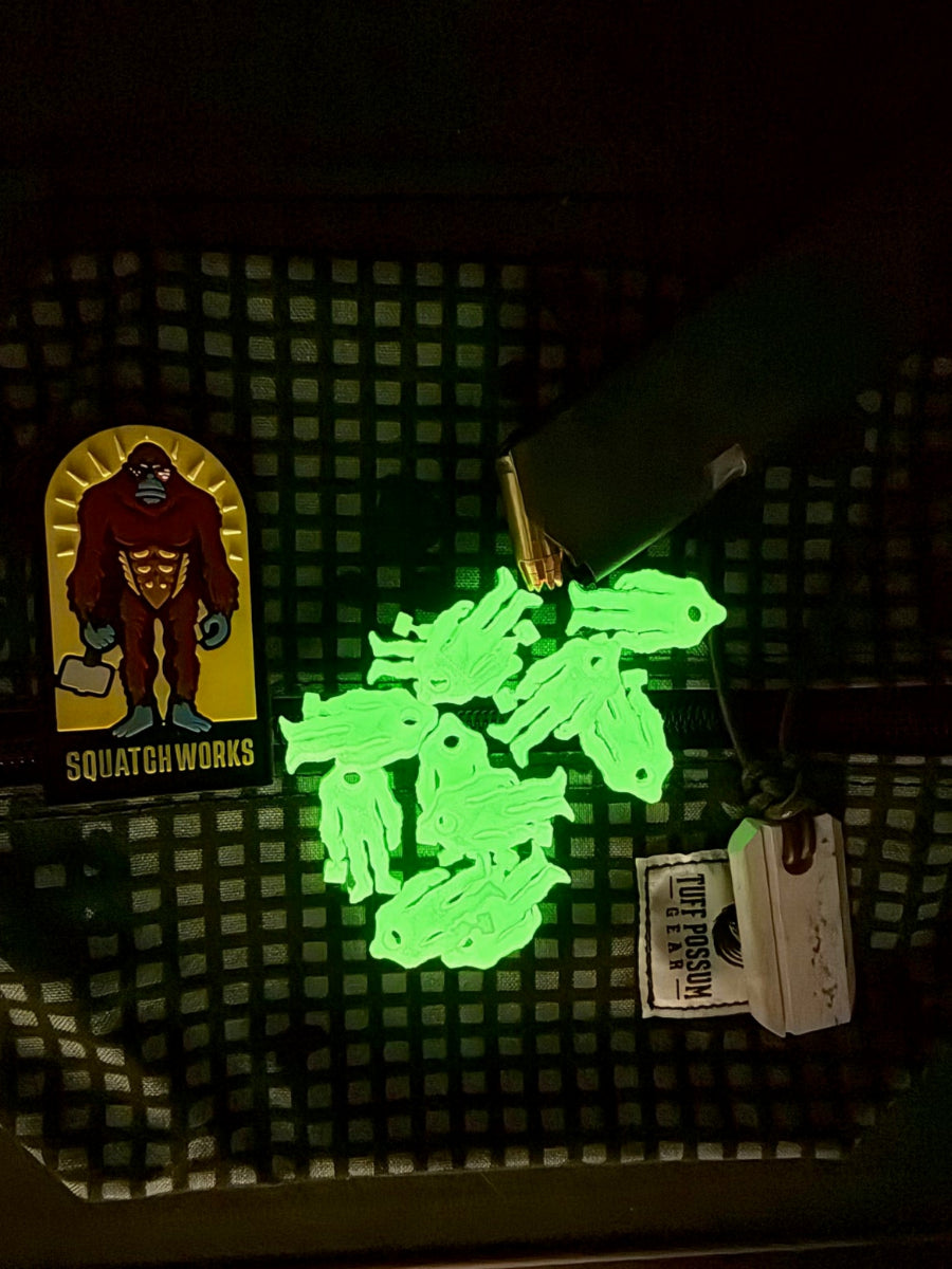 Squatch Works glow-in-the-dark lanyard bead featuring the signature Squatch Works logo, perfect for enhancing visibility and style on your gear.